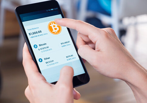 Woman using a smart phone displaying a bitcoin wallet screen.